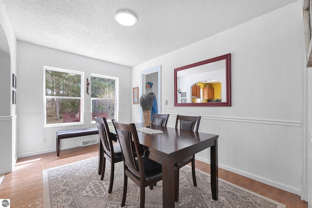 9916 S M-37, Buckley, MI 49620 - dining room featuring a wainscoted wall, a textured ceiling, and wood finished floors