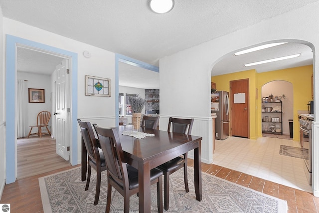 9916 S M-37, Buckley, MI 49620 - dining space with light wood-style floors, arched walkways, and a textured ceiling