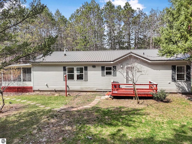 9916 S M-37, Buckley, MI 49620 - rear view of house with a lawn, metal roof, and a wooden deck