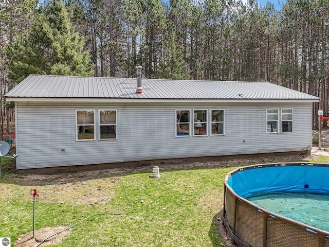 9916 S M-37, Buckley, MI 49620 - rear view of house featuring a yard, metal roof, and an outdoor pool