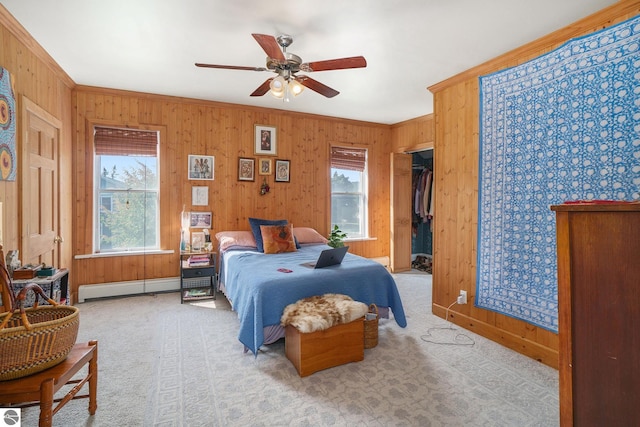carpeted bedroom featuring ornamental molding, a ceiling fan, a baseboard heating unit, and wooden walls