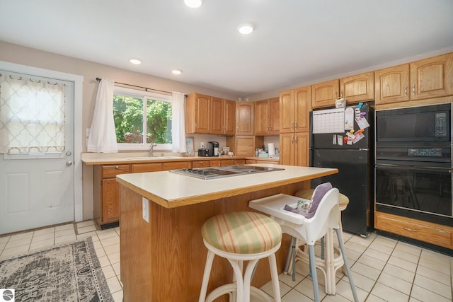 kitchen with light countertops, light tile patterned floors, a sink, and black appliances
