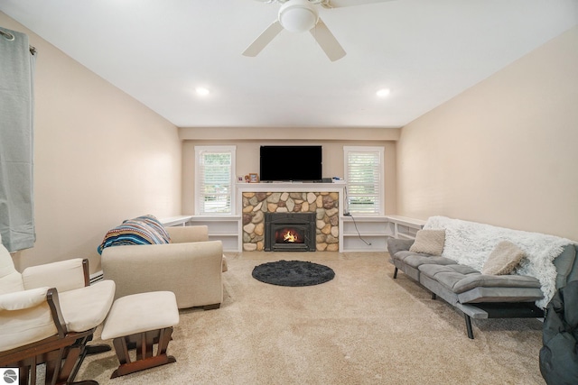 living room with carpet, ceiling fan, a wealth of natural light, and a fireplace