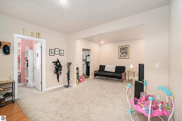 recreation room with baseboards and carpet