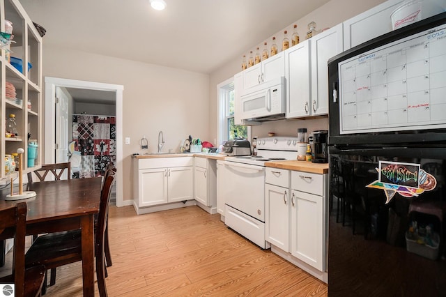 kitchen with wooden counters, white cabinetry, a sink, white appliances, and light wood-style flooring