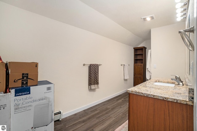 bathroom featuring visible vents, baseboard heating, wood finished floors, baseboards, and lofted ceiling