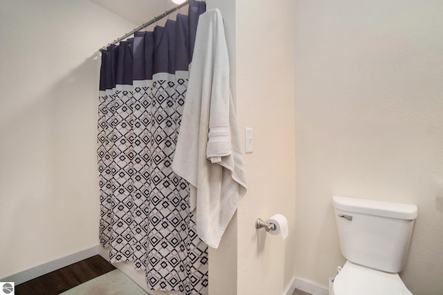 full bathroom featuring baseboards, toilet, curtained shower, and wood finished floors