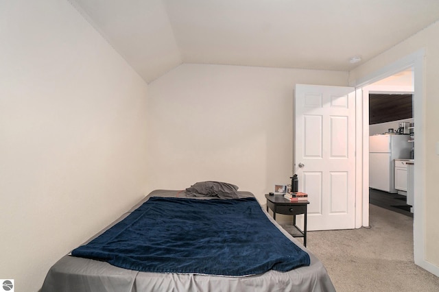 bedroom with freestanding refrigerator, carpet flooring, and vaulted ceiling