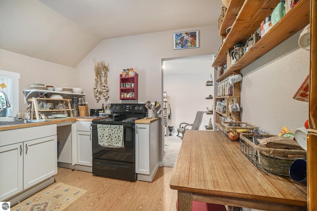 kitchen with electric range, light wood-type flooring, a sink, lofted ceiling, and white cabinetry