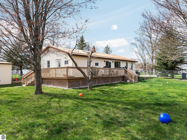 431 E Bittner Ave, Reed City, MI 49618 - rear view of house featuring fence, a wooden deck, a chimney, and a yard