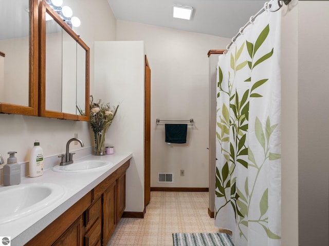 431 E Bittner Ave, Reed City, MI 49618 - full bathroom with visible vents, double vanity, baseboards, tile patterned floors, and a sink