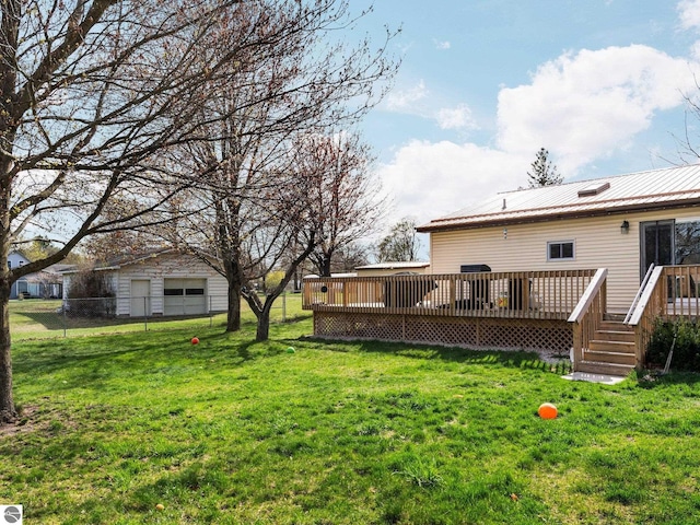 431 E Bittner Ave, Reed City, MI 49618 - view of yard featuring a garage, fence, and a deck