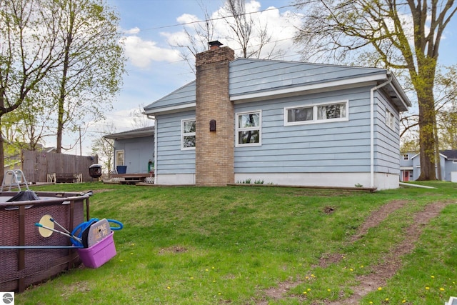 422 W Center, Alma, MI 48801 - back of house with a lawn, fence, and a chimney