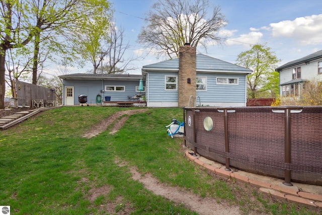 422 W Center, Alma, MI 48801 - back of property with a lawn, fence, and a chimney