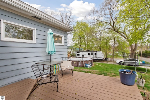 422 W Center, Alma, MI 48801 - wooden terrace with a trampoline, a jacuzzi, a yard, and visible vents