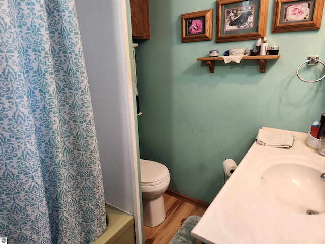 bathroom featuring a sink, toilet, and wood finished floors
