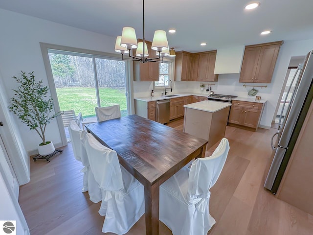 dining area with recessed lighting, baseboards, an inviting chandelier, and light wood-style floors
