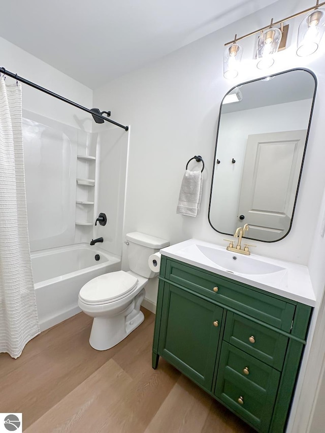 full bath with toilet, shower / bath combo with shower curtain, wood finished floors, and vanity
