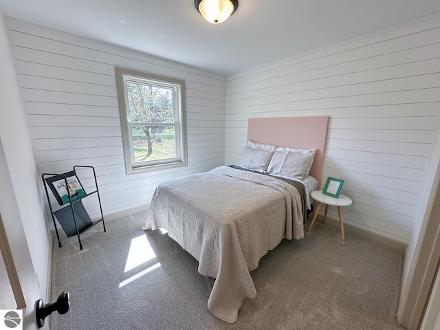 bedroom with wooden walls, baseboards, and carpet