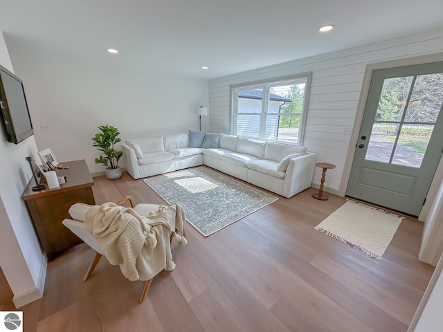 living area with recessed lighting, wood finished floors, and a healthy amount of sunlight