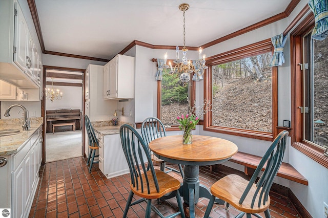 dining space with an inviting chandelier, baseboards, brick floor, and ornamental molding