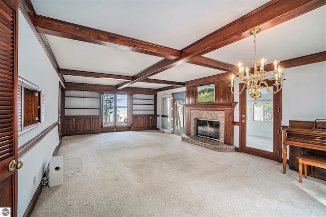 unfurnished living room with carpet, beam ceiling, a notable chandelier, and a fireplace