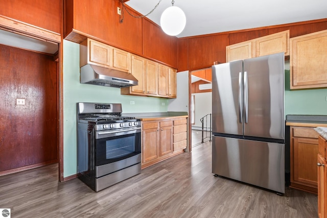 kitchen with light wood-style floors, light countertops, stainless steel appliances, and under cabinet range hood