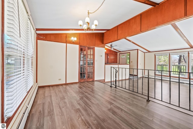 interior space featuring wood finished floors, baseboards, baseboard heating, a baseboard radiator, and ceiling fan with notable chandelier