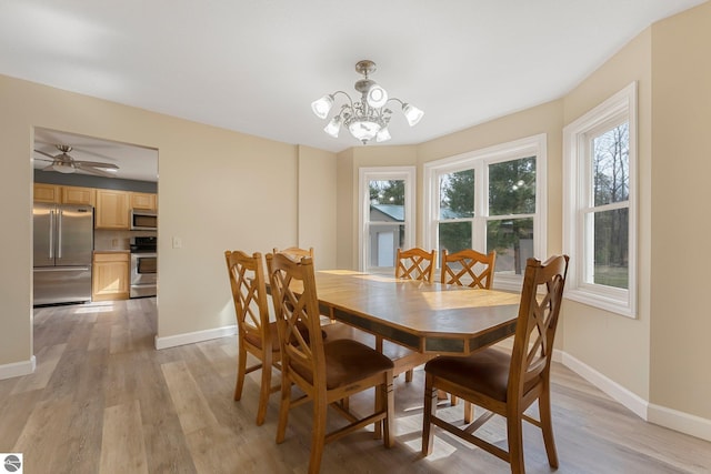 dining area featuring baseboards, an inviting chandelier, and light wood-style floors
