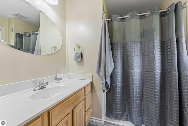 bathroom featuring vanity, curtained shower, and visible vents
