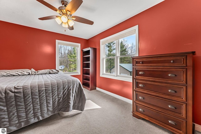 bedroom with carpet floors, multiple windows, baseboards, and ceiling fan