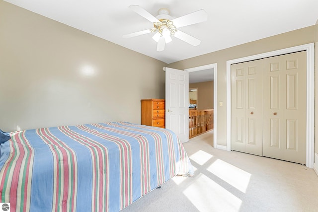 bedroom with a closet, ceiling fan, and light carpet