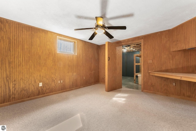 unfurnished bedroom with baseboards, a ceiling fan, and wood walls