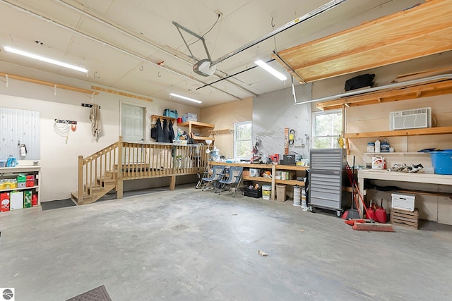 garage featuring a workshop area, a garage door opener, and a wall mounted AC