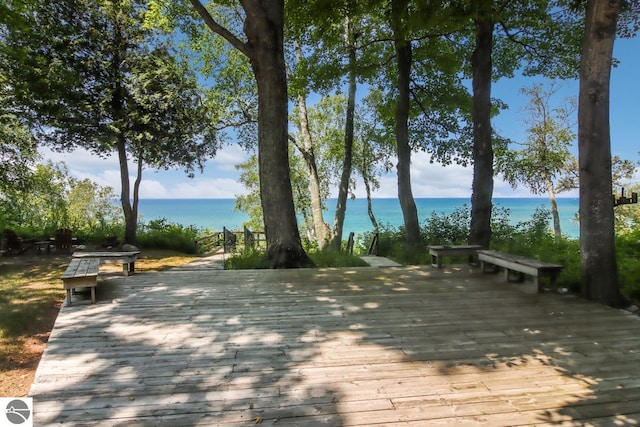 surrounding community with a deck with water view