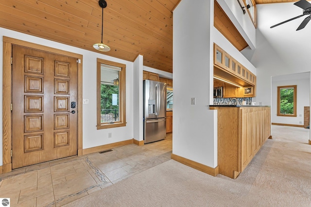 entryway featuring baseboards, wood ceiling, ceiling fan, and visible vents