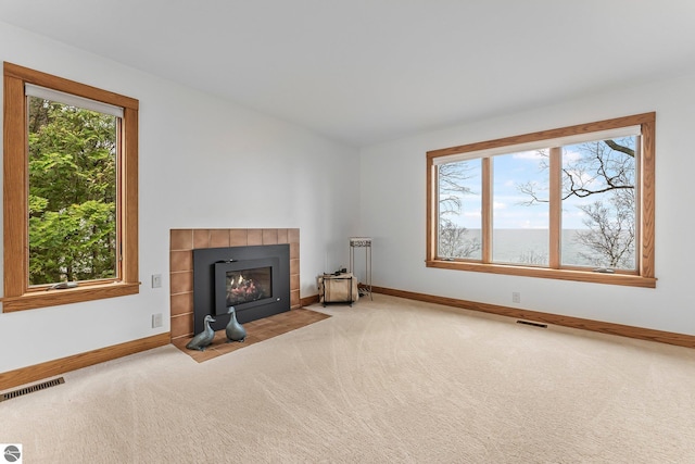 unfurnished living room with a fireplace, baseboards, and carpet