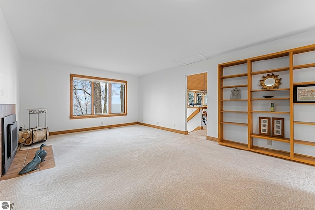 unfurnished living room featuring baseboards, light carpet, and a wealth of natural light
