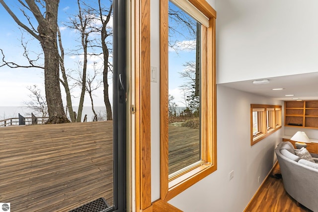 doorway to outside with baseboards and wood finished floors