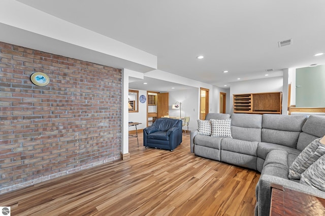 living area featuring recessed lighting, brick wall, visible vents, and light wood-style floors