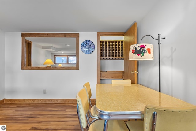 dining area with baseboards and wood finished floors