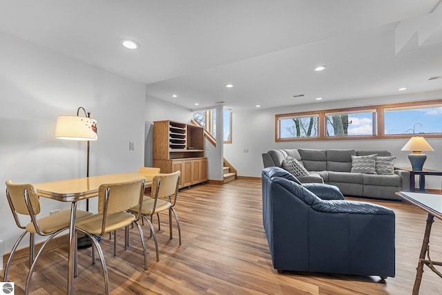 living area with recessed lighting, baseboards, wood finished floors, and stairway