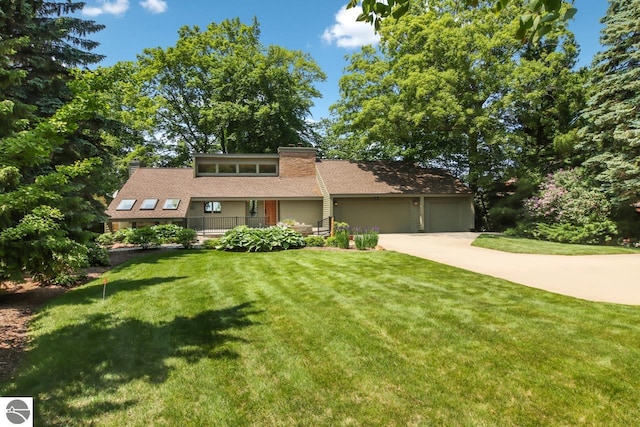 mid-century home featuring a garage, concrete driveway, and a front yard