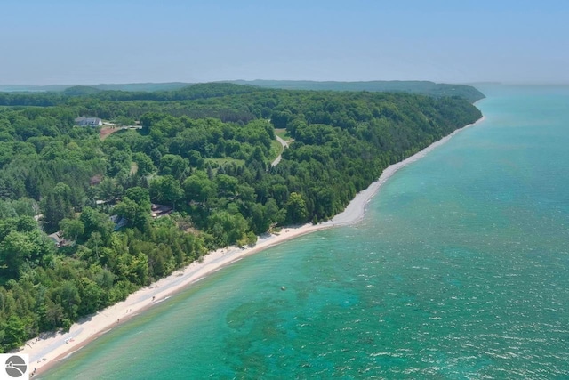 birds eye view of property with a beach view, a view of trees, and a water view