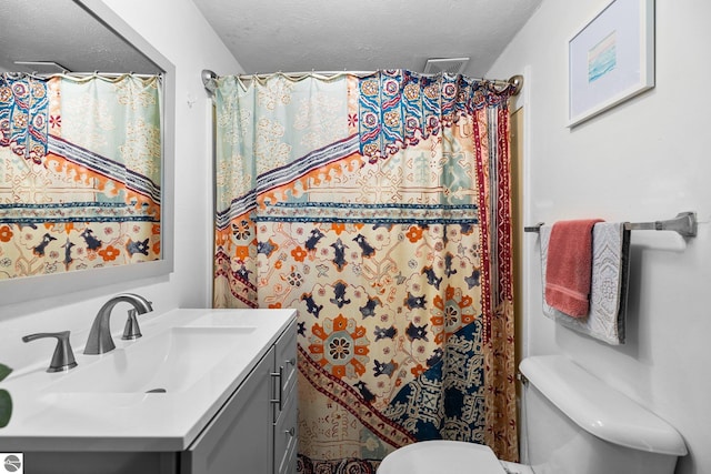 bathroom with vanity, toilet, a textured ceiling, and a shower with shower curtain