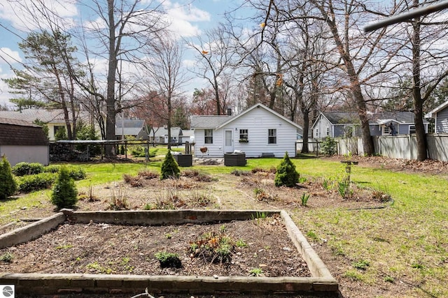 view of yard with fence, a residential view, cooling unit, and a vegetable garden