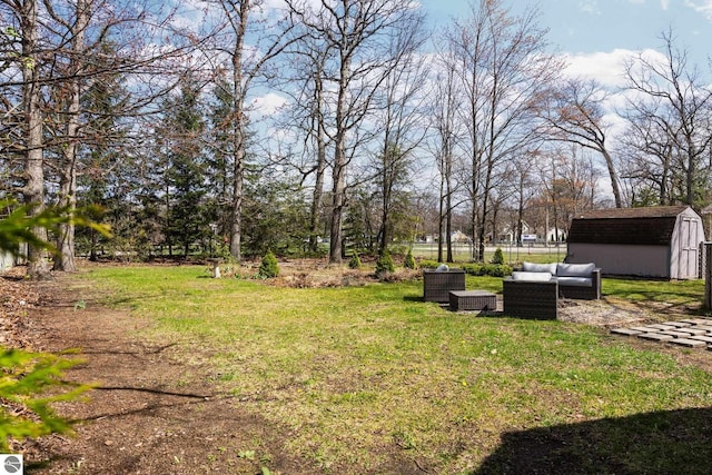 view of yard with an outdoor structure, fence, a shed, and an outdoor living space