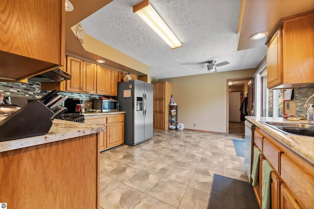kitchen with a sink, decorative backsplash, appliances with stainless steel finishes, and light countertops