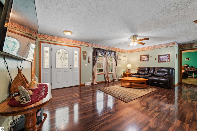 living area with a ceiling fan, a textured ceiling, baseboards, and wood finished floors