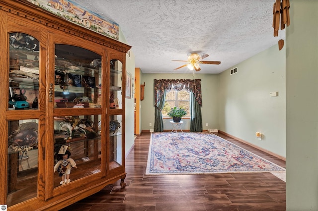 foyer with visible vents, wood finished floors, baseboards, ceiling fan, and a textured ceiling